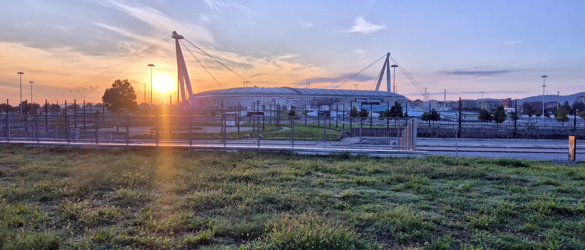 The Allianz Stadium at dawn, seen from the fields beside the farmhouse